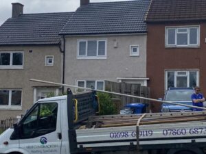 Residential roof fitted with solar panels and grey roof tiles